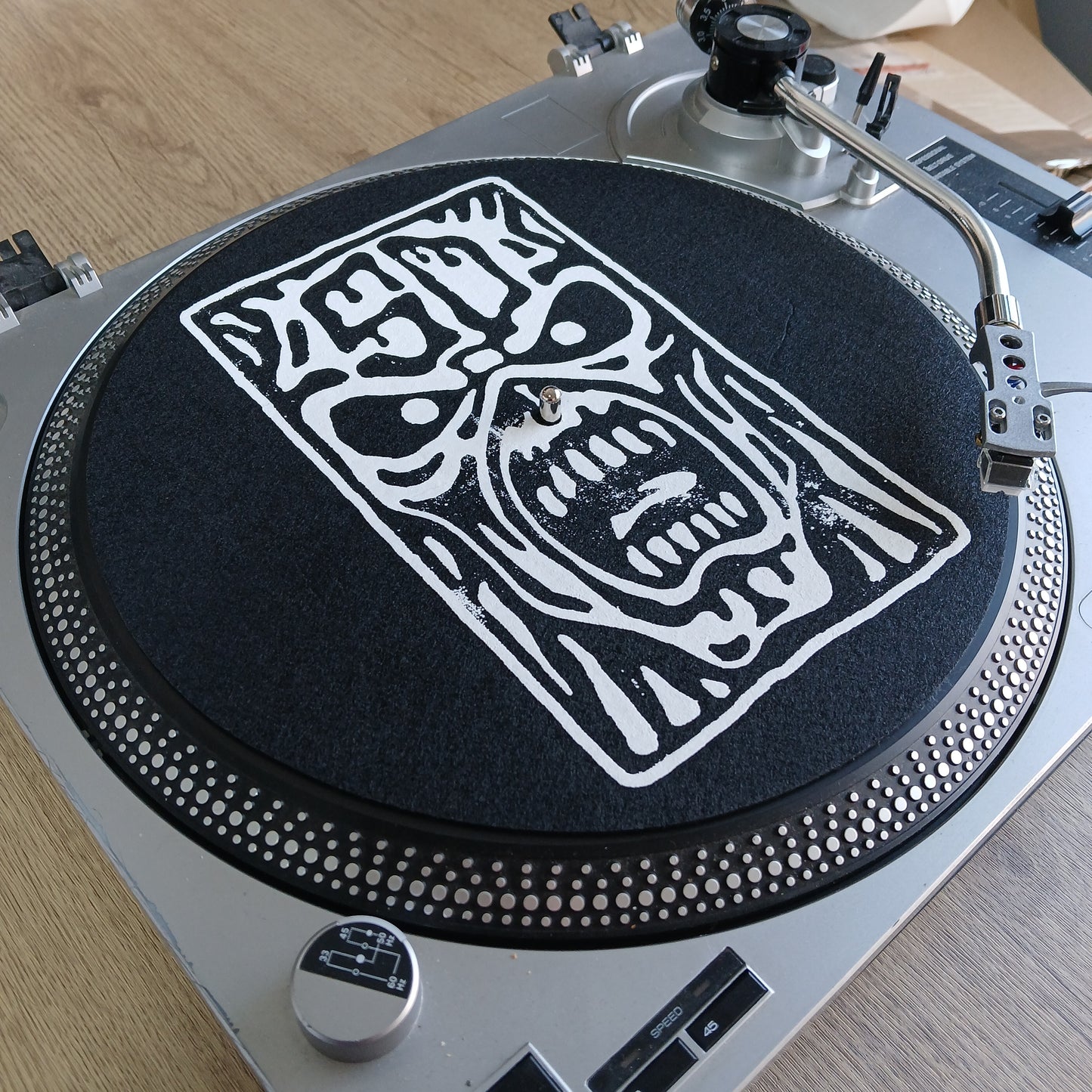 Close-up of a DJ turntable with an Iron Maiden Eddie logo on the platter