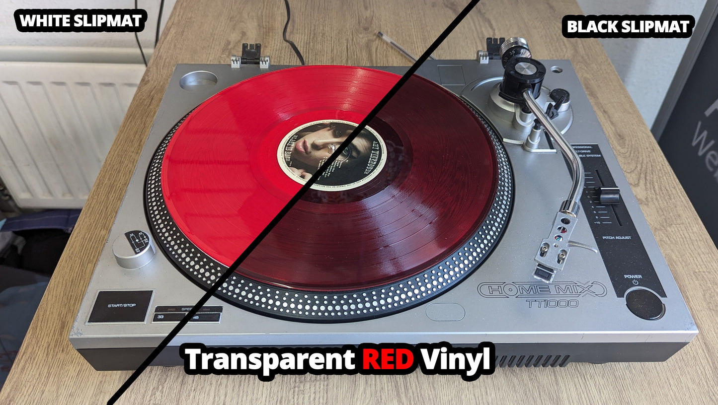 Turntable with transparent red vinyl on a wooden surface, labeled for white and black slipmat options.