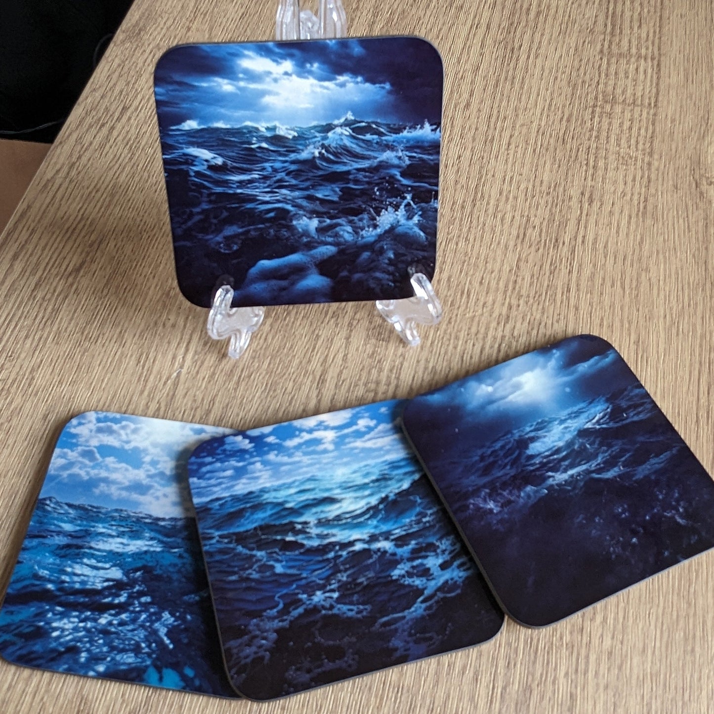 Three coasters with ocean design on a wooden surface