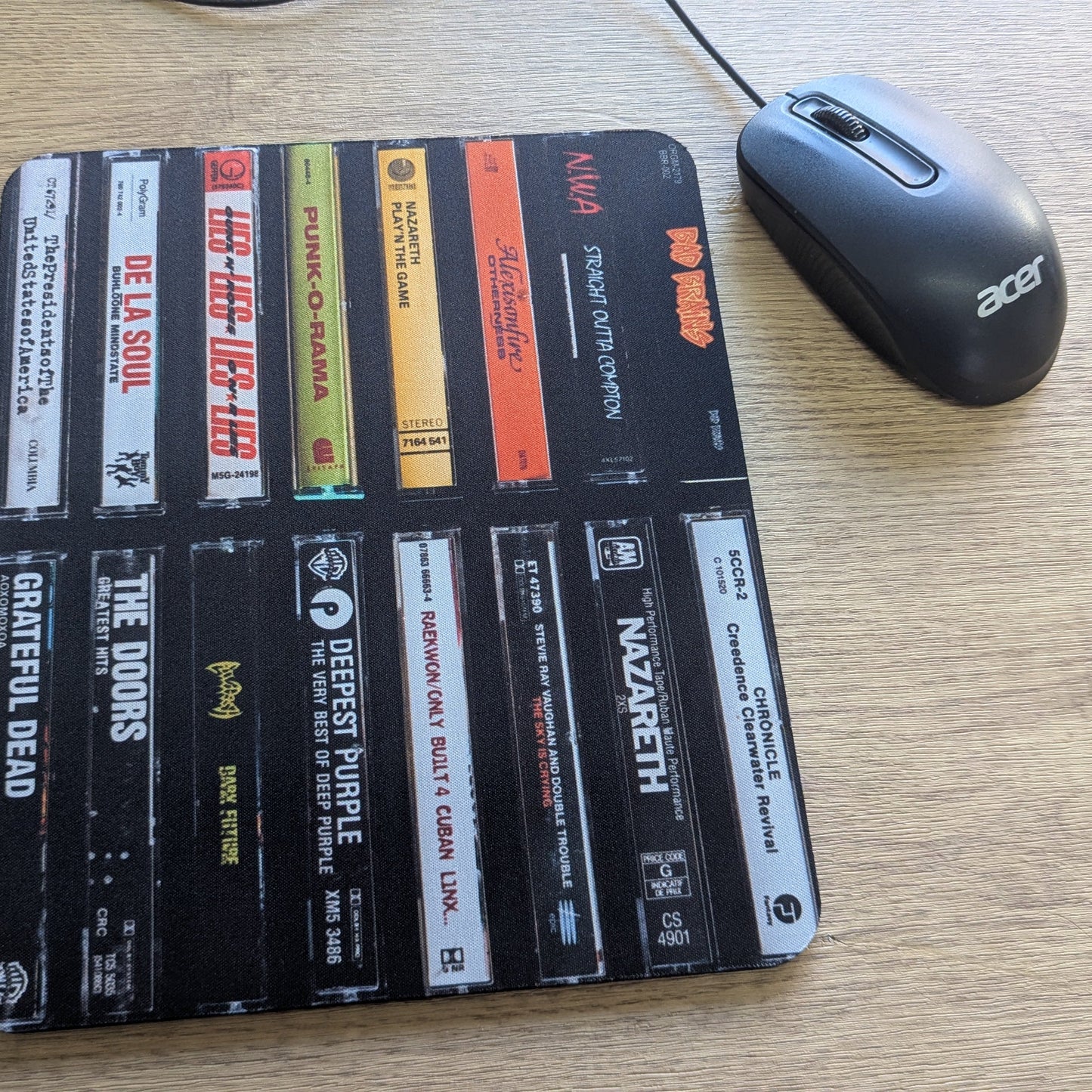 Mouse pad with cassette tape design on a desk next to a mouse