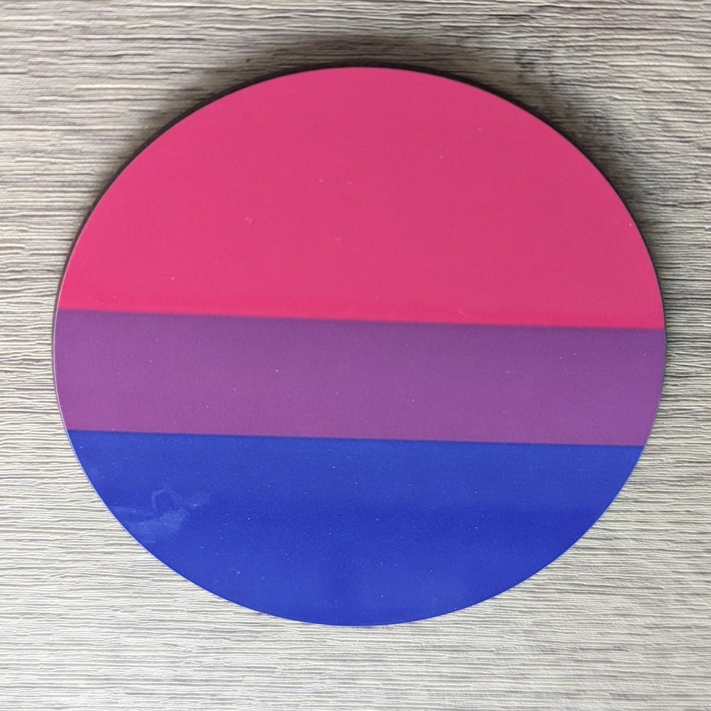 bisexual pride ith blue and pink gradient on a wooden surface